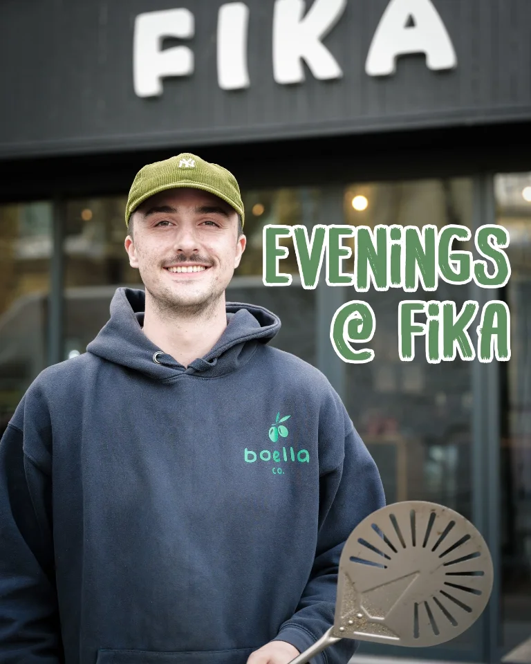 Outside Fika with a pizza peel, beneath lettering reading Evenings @ Fika